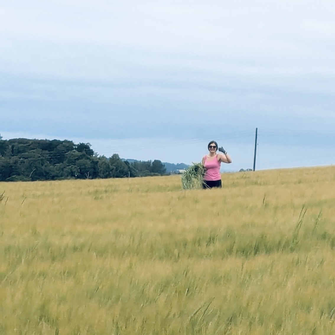 Ashley giving a thumbs up while working the crop fields at her mum's farm