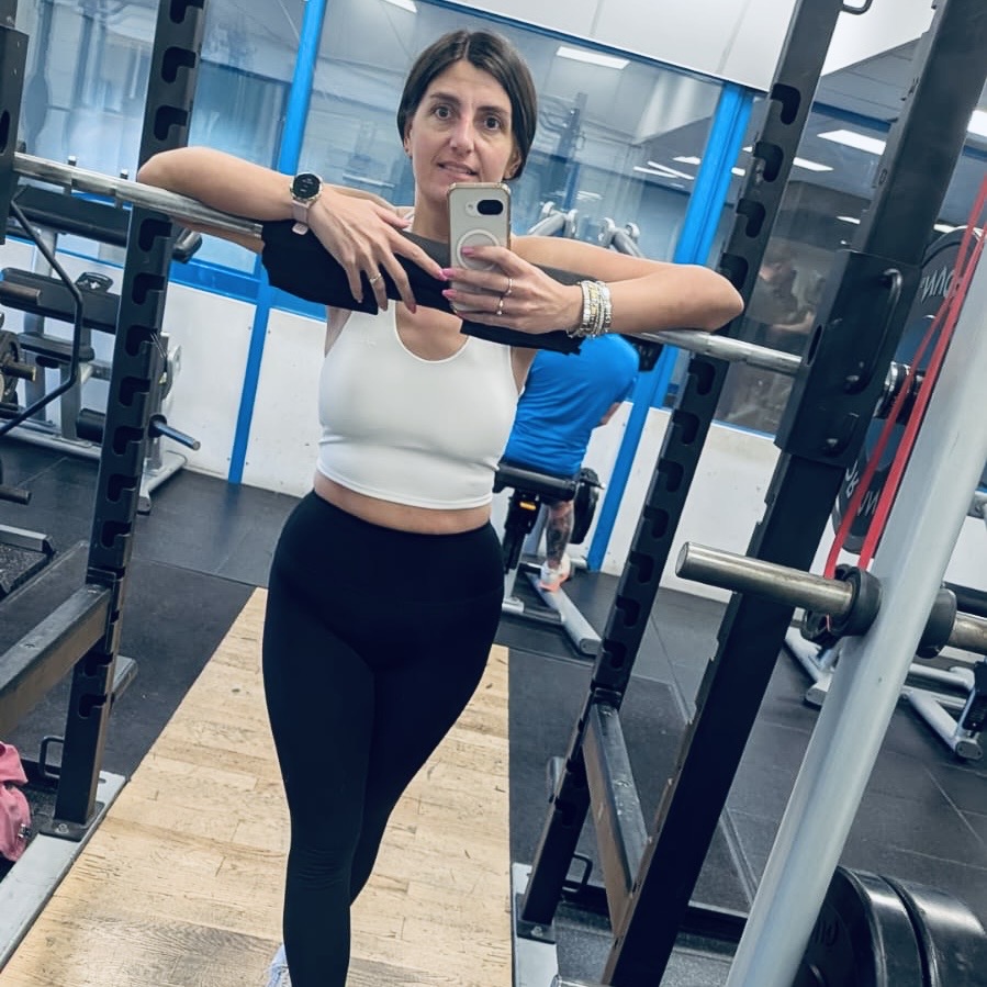 Ashley taking a selfie at the squat rack in the gym