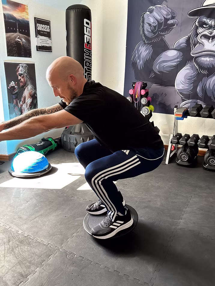 Squat on balance board showing core stability training