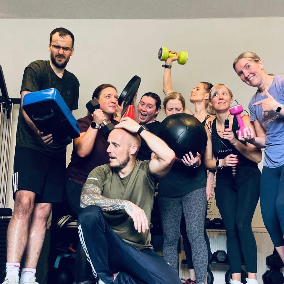 The Friday night circuits group in the Elgin studio, holding dumbbells and a medicine ball