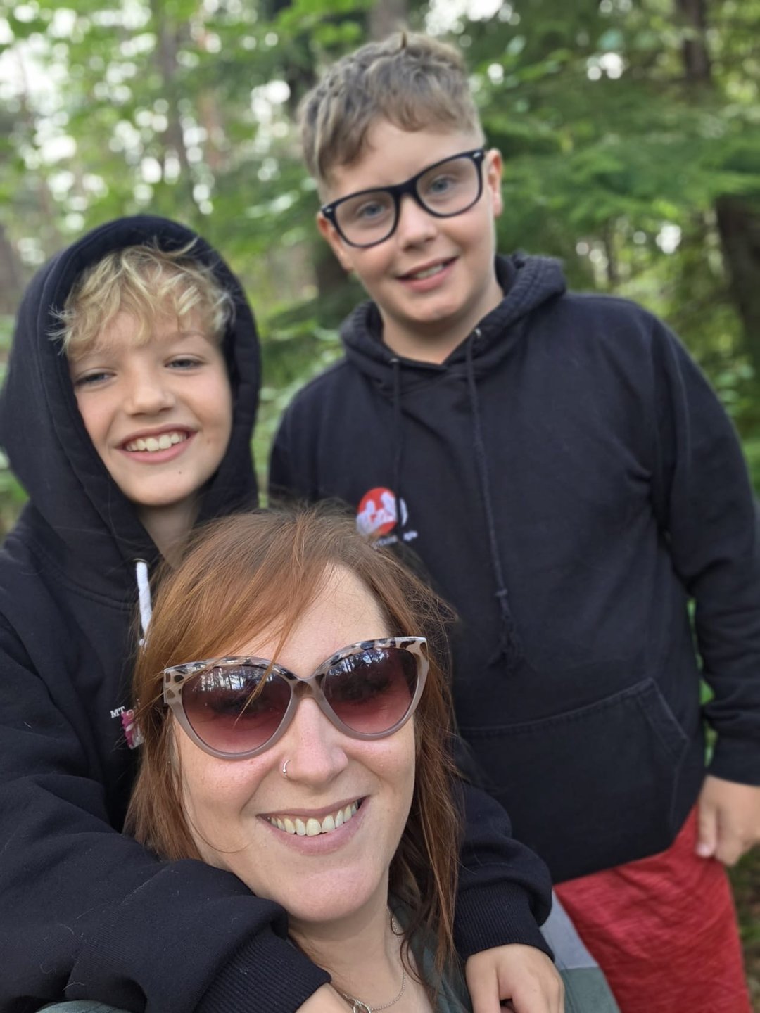 Gemma and her two boys smiling on a woodland walk