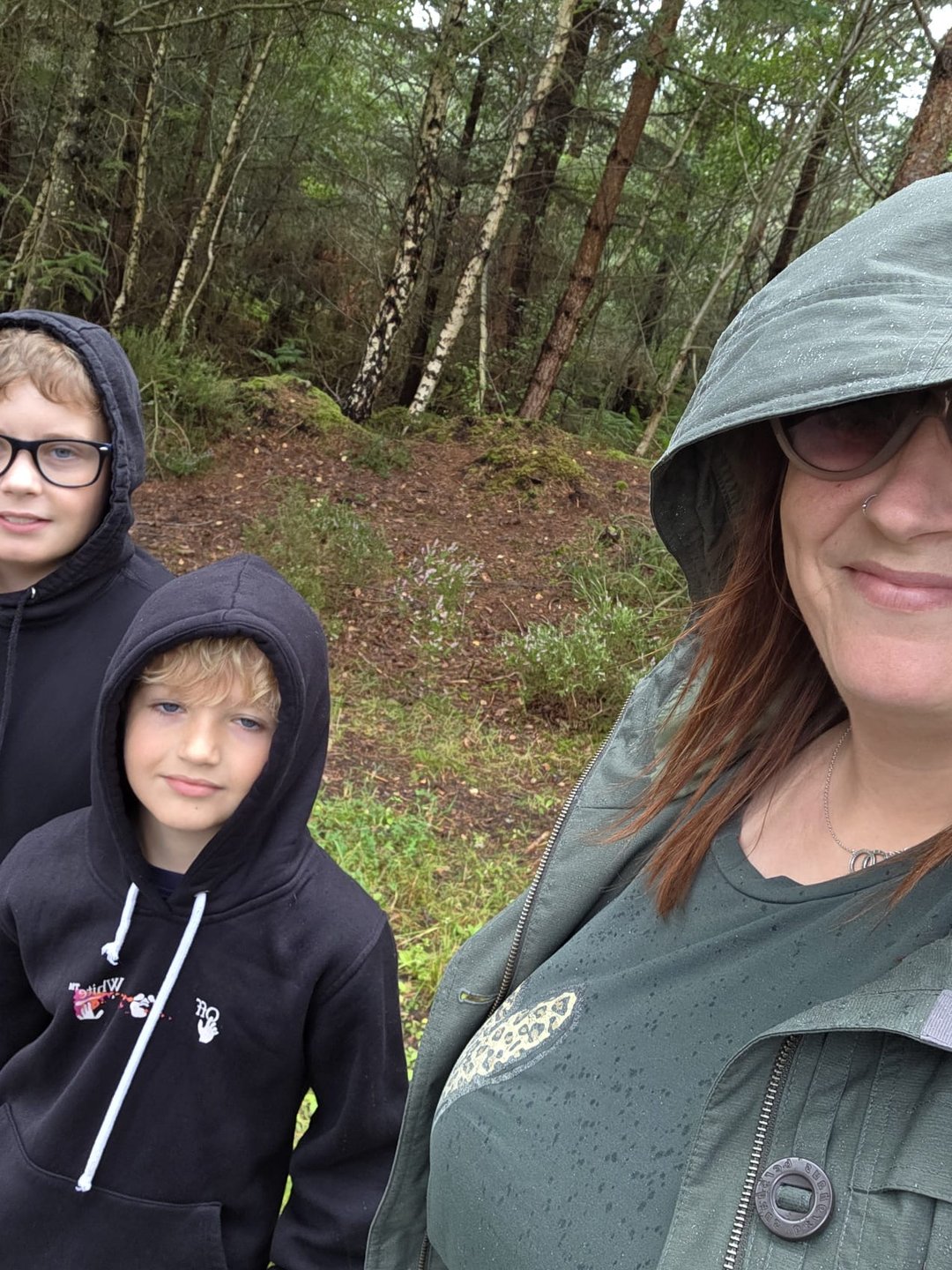 Gemma and her two boys under hoods on the same walk, soaked