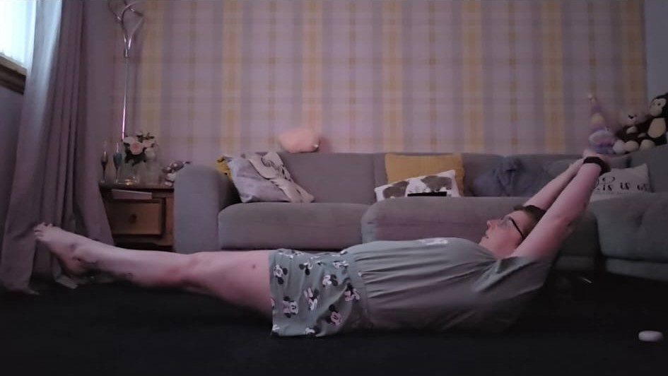 Lyndsey holding a hollow hold on her living room floor on day three