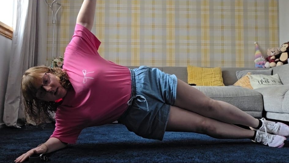 Lyndsey holding a side plank with her arm raised on day four