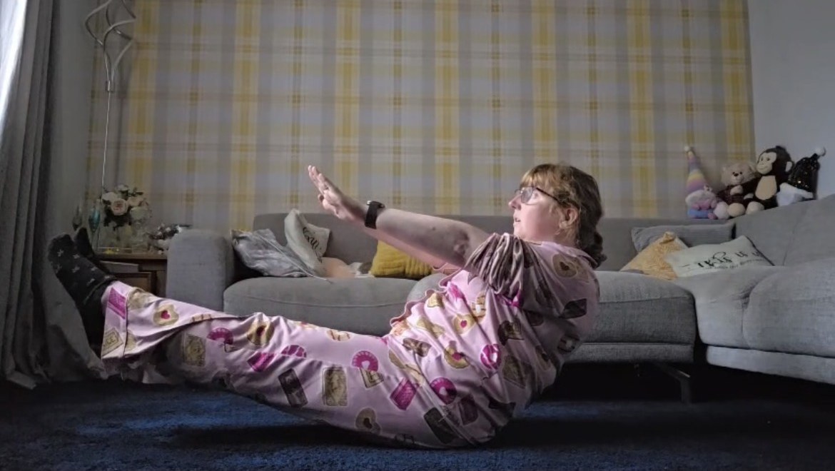Lyndsey holding a V-sit with arms reached forward on day five
