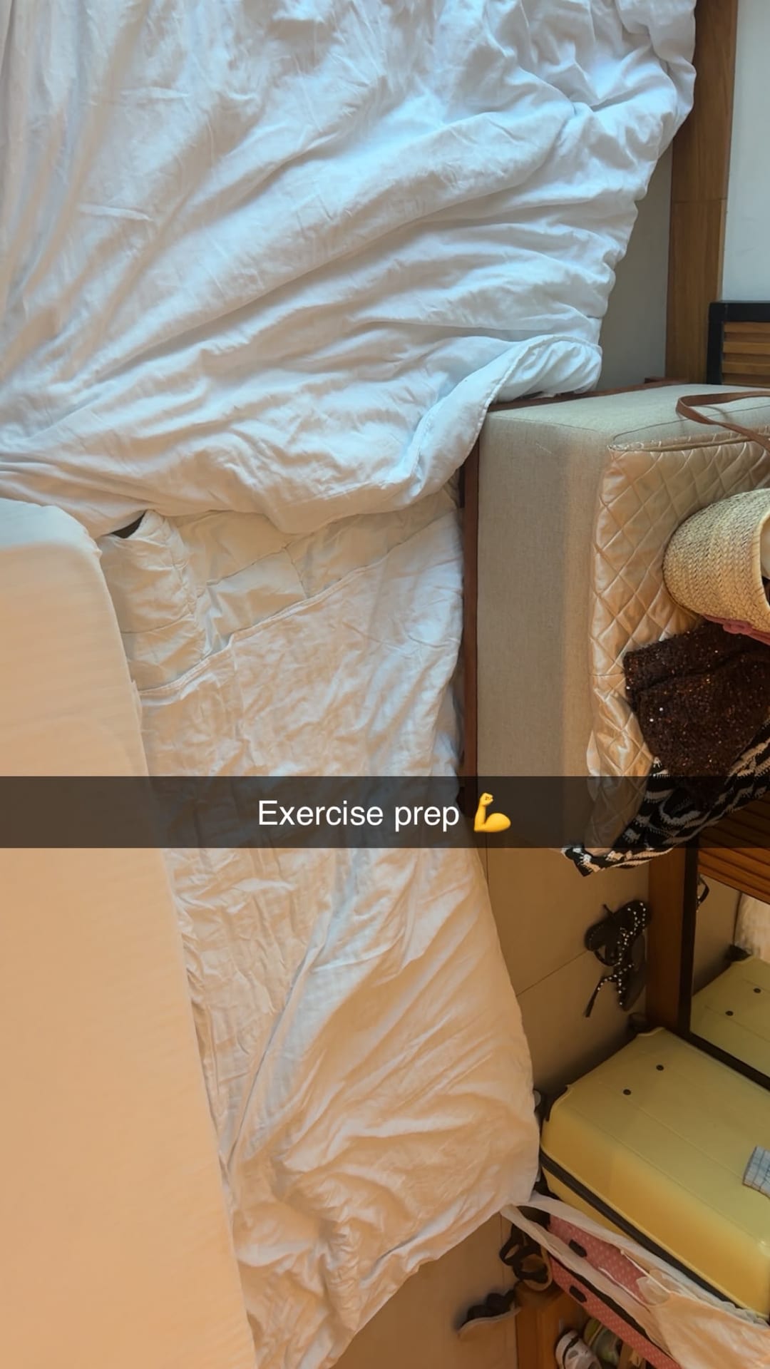 A hotel room with the bed pushed aside, captioned exercise prep